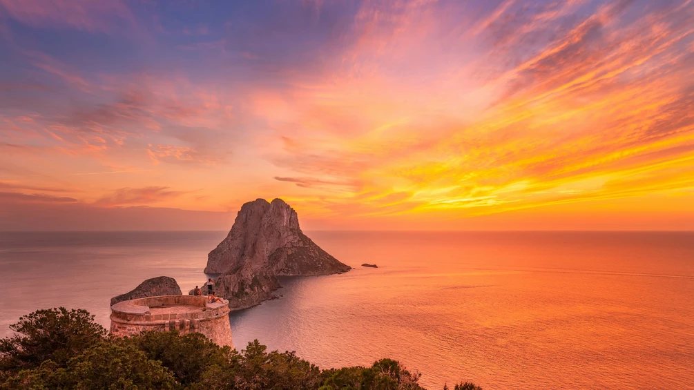 Es Vedra island at sunset showing mystical cliffs and glowing sky in Ibiza